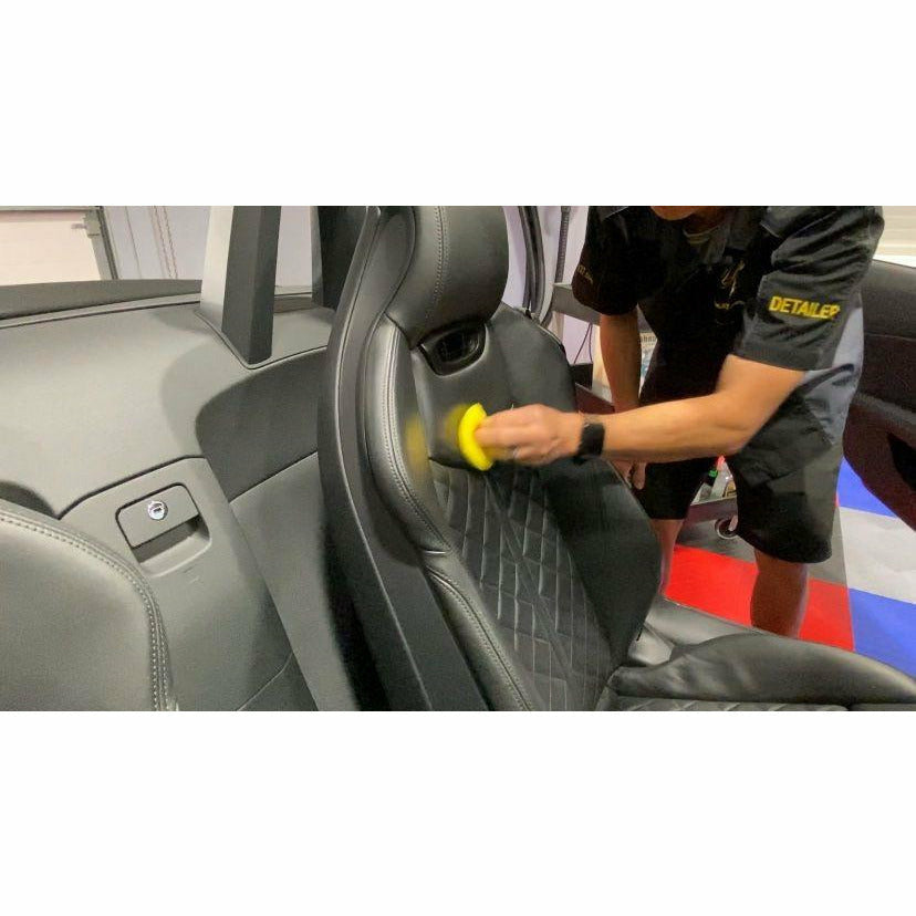 Car Detailer Cleaning and Protecting Leather Vehicle Interior
